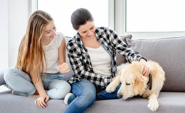 Daughter and mother next to dog - Foto, imagen