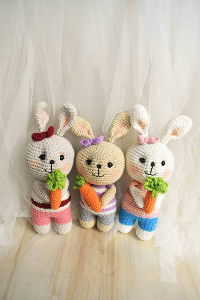 ウサギのかぎ針編みかわいいウサギ手作りヴィンテージの背景家の装飾素敵な動物のかぎ針編みウールの柔らかいおもちゃ子供のための創造的なアイデアの贈り物ニットデザインパステルカラーのテーマ子供時代 - 写真・画像