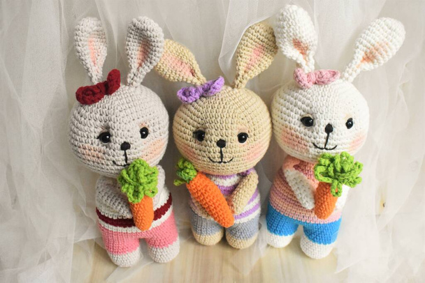 ウサギのかぎ針編みかわいいウサギ手作りヴィンテージの背景家の装飾素敵な動物のかぎ針編みウールの柔らかいおもちゃ子供のための創造的なアイデアの贈り物ニットデザインパステルカラーのテーマ子供時代 - 写真・画像