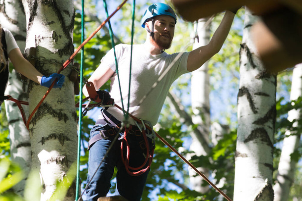 Aventura de cuerda - un hombre de pie junto al árbol y mirando hacia abajo
 - Foto, Imagen