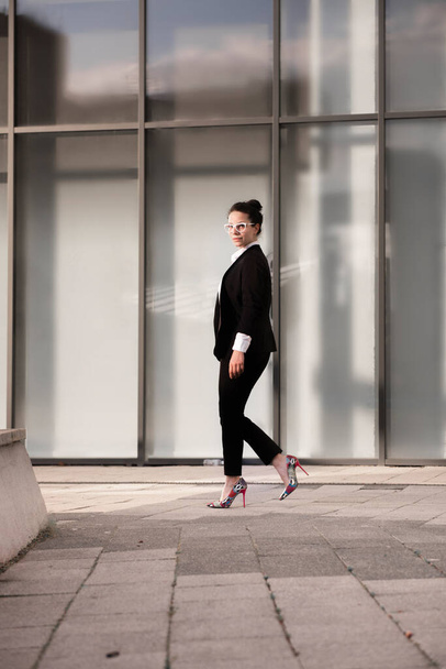 Retrato poderoso de uma pequena empresária em pé na frente de seu local de trabalho moderno
. - Foto, Imagem