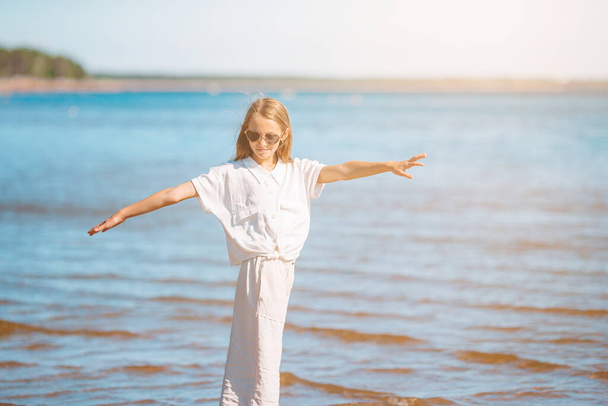 Schattig klein meisje aan het strand tijdens de zomervakantie - Foto, afbeelding