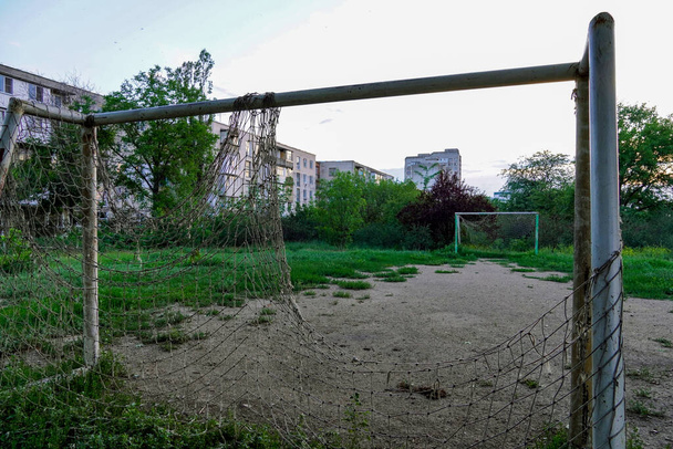 elhagyott focipálya, gól egy szakadt hálóval egy üres telken - Fotó, kép