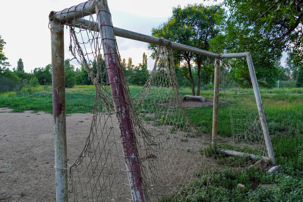 elhagyott focipálya, gól egy szakadt hálóval egy üres telken - Fotó, kép