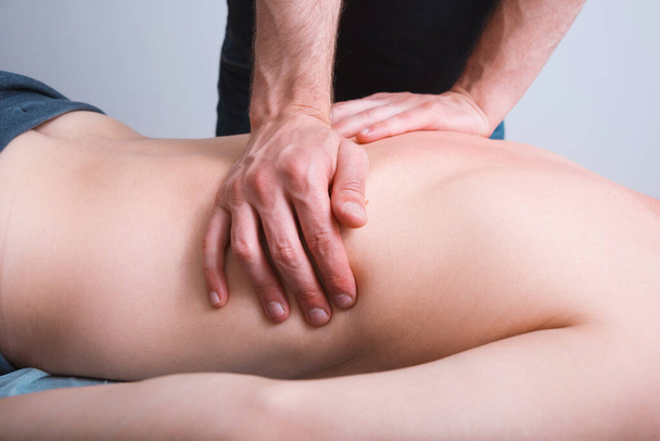 Physiothérapeute fait un massage profond sur un dos mans. - Photo, image