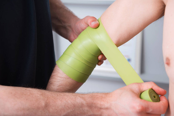 Elbow pain therapy with kinesio green tape.  - Foto, Imagen