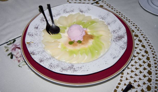 belamente serviu a sobremesa saborosa em um grande prato em uma toalha de mesa branca reto com fruto
 - Foto, Imagem