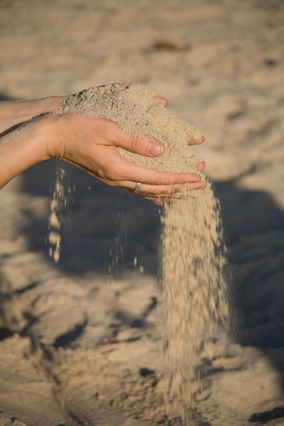 close-up of hands with sand falling on a golden beach - Foto, Imagem