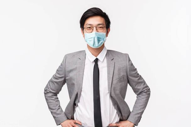 Vamos ganhar algum dinheiro. Bonito confiante e inteligente asiático empresário de terno e gravata, de pé em pronto, determinada pose, sorrindo otimista, assegurado ele vai ficar negócio, fundo branco
 - Foto, Imagem