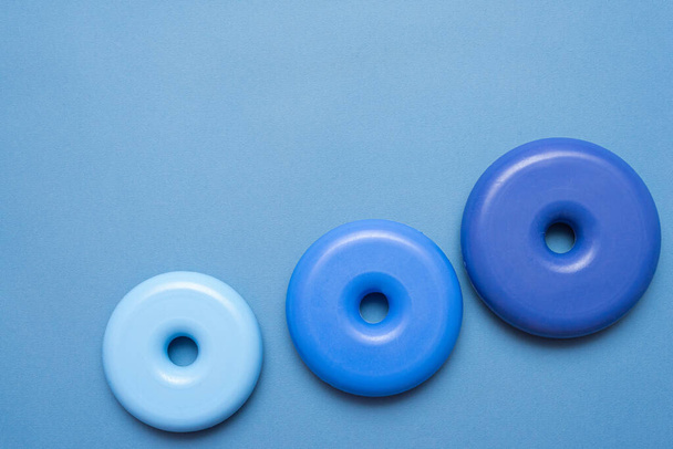 Blue baby toys a bagels on blue background with copy space. Tow view. - Zdjęcie, obraz