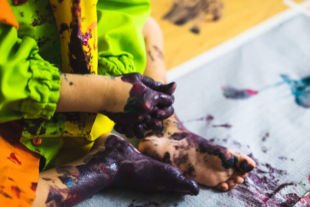 Pequeño niño manos y pies cubiertos de múltiples colores
 - Foto, Imagen