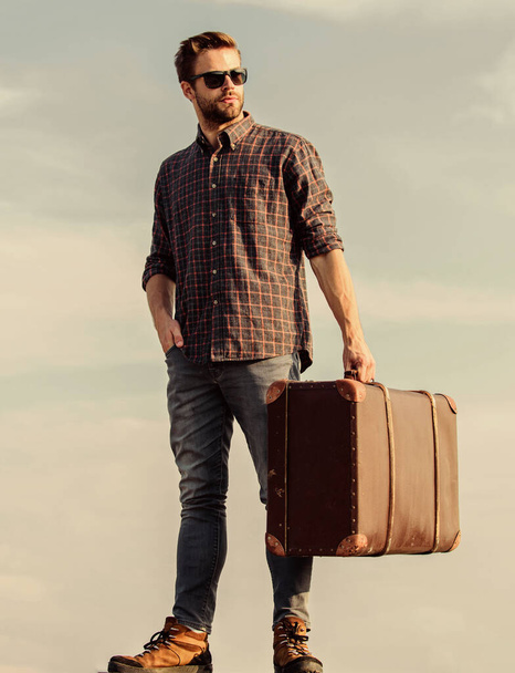 Travel with luggage. Travel blogger. Man carrying his things in baggage. Vacation time. Travel agency. Business trip. Handsome guy traveler. Guy outdoors with vintage suitcase. Luggage concept - 写真・画像