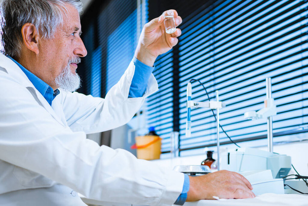 Senior male researcher carrying out scientific research in a lab (shallow DOF; color toned image) - Fotoğraf, Görsel