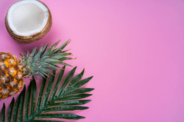 tropické pozadí růžové s kokosovým ořechem a ananasem horní pohled - Fotografie, Obrázek