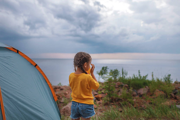 家族の休暇だ。キャンプ場のキャンプ場に座って日没を見ている子供、健康的なアクティブなライフスタイル、ロックダウン後の安全な夏の滞在 - 写真・画像