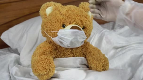 Teddy bear measure the temperature by hand. The doctor makes a measurement of temperature by applying a hand to his forehead. The doctor shows a finger down means that the temperature is elevated. - Filmagem, Vídeo