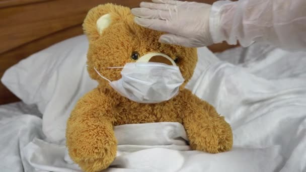 Teddy bear measure the temperature by hand. The doctor makes a measurement of temperature by applying a hand to his forehead. The doctor shows a thumbs up means that the temperature is elevated. - Filmagem, Vídeo