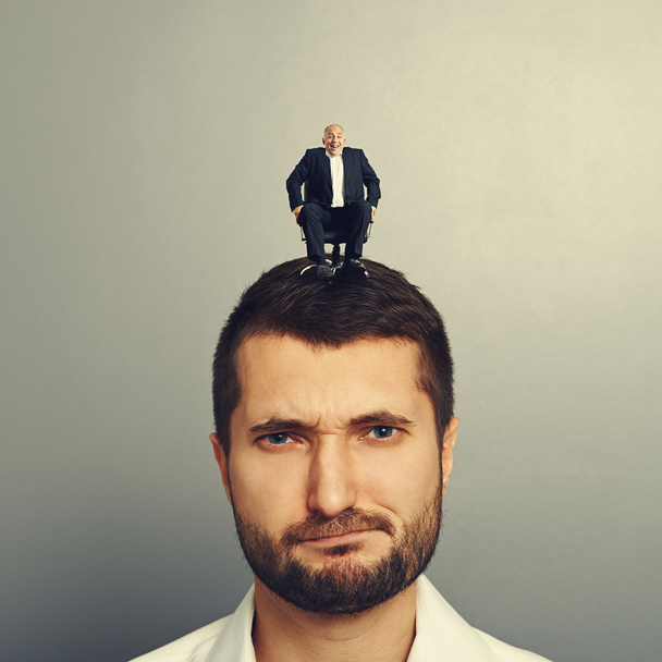 nespokojený muž s malým šéfem na hlavu - Fotografie, Obrázek