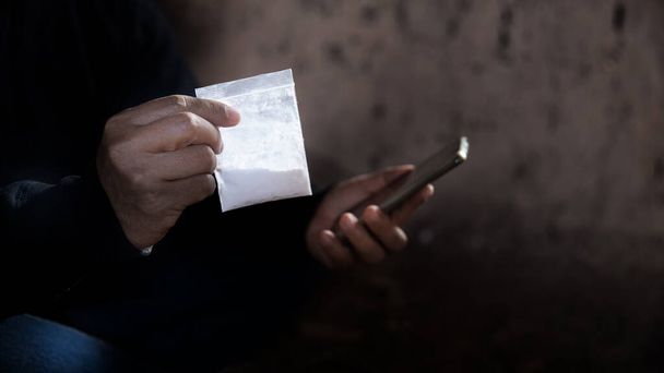 Он наркодилер. Мужчина звонит продает наркотики по телефону и он наркоман или наркотик с копировальным пространством
 - Фото, изображение