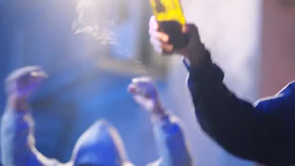 Молодой афроамериканец в маске, держа в руках и бросая коктейль Молотова, протестуя в грязной толпе. Мужчина-протестующий запускает бутылку с огнём на улице. Агрессивное проявление
. - Кадры, видео