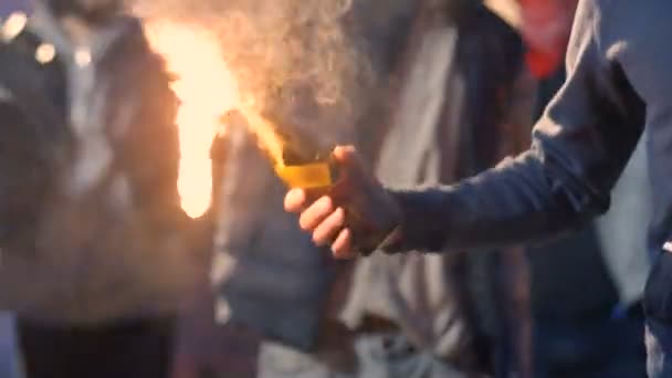 Jonge blanke man met masker op gezicht die Molotov cocktail vasthoudt en gooit terwijl hij protesteert in rommelige menigte. Mannelijke demonstrant lanceert vuurfles bij straatrellen. Agressieve manifestatie. - Video