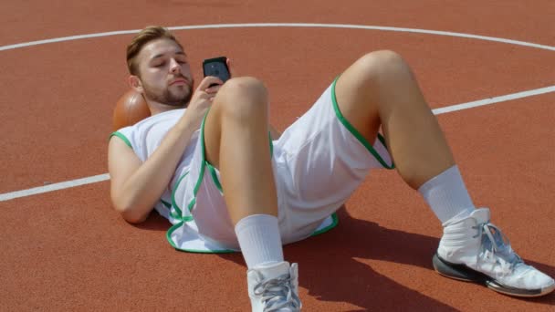 Basketball Fan Reaction Concept - Eccitato giocatore di basket in costume da basket guardando la sua squadra preferita su smartphone, 4k rallentatore - Filmati, video