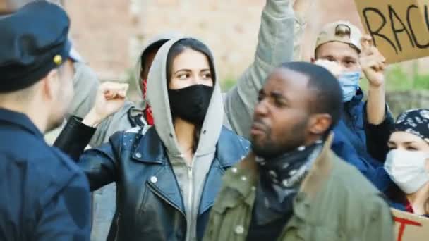Beyaz polis ve Afrikalı Amerikalı protestocu erkek protestocuların tezahür sırasında sokak ortasında kavga edip kavga etmeleri. Polis ve çok ırklı erkek ve kadın protestocular arasında çatışma var. Açık havada.. - Video, Çekim