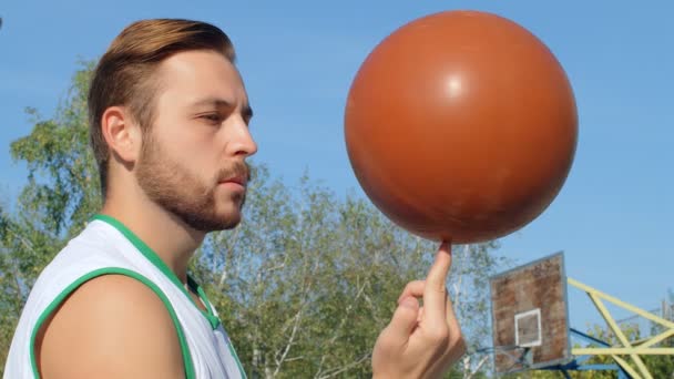 Koripalloilijan muotokuva pyörittää palloa, 4k hidastettuna - Materiaali, video