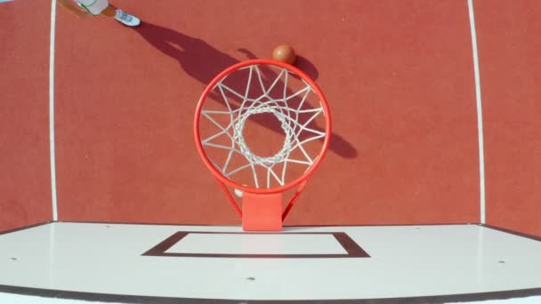 Drone tiro de tipo lanzando una pelota de baloncesto en un aro, 4k
 - Metraje, vídeo