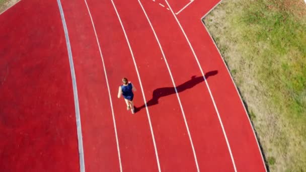 Ylin näkymä radan juoksija urheilija käynnissä stadionin kaistalla, 4k - Materiaali, video