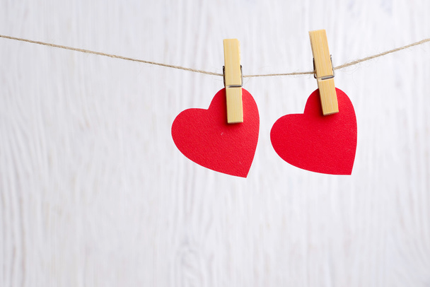rode harten opknoping op houten achtergrond - Foto, afbeelding