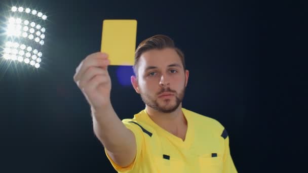 Calcio Arbitro di calcio su sfondo nero con penalità cartellino giallo, 4k - Filmati, video