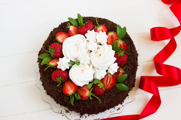 Chocoladetaart met aardbeien, wit bord met kopieerruimte, rood lint - Foto, afbeelding
