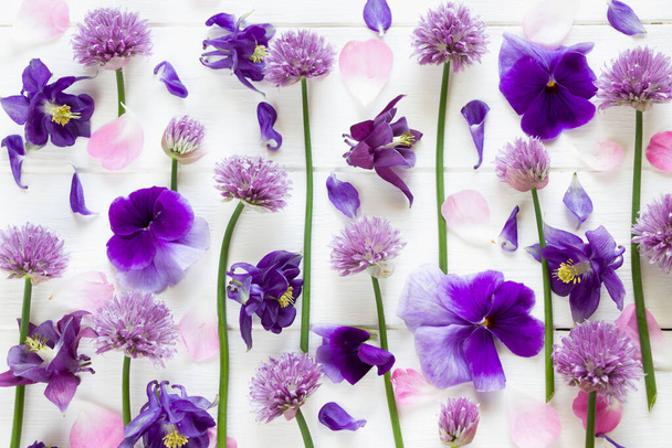 Flores de diseño plano, flores púrpura y rosa sobre tabla de madera blanca, patrón floral en estilo laico plano. Plantilla para tarjeta de felicitación
 - Foto, imagen