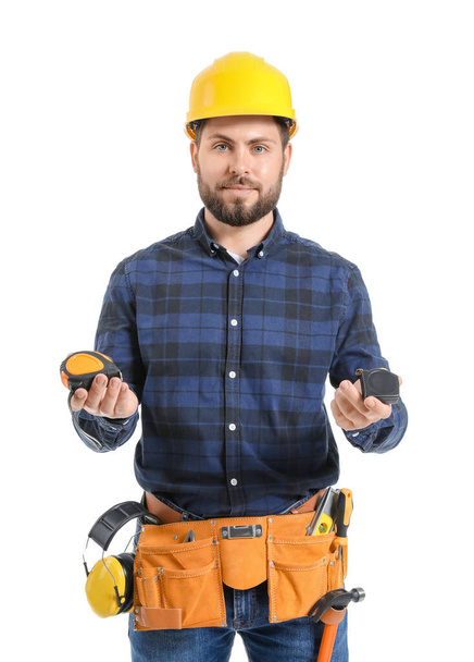Male worker with measuring tapes on white background - Φωτογραφία, εικόνα