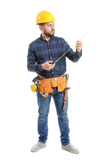 Trabajador masculino con cinta métrica sobre fondo blanco
 - Foto, imagen