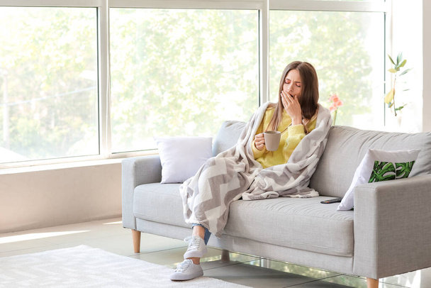 Junge Frau leidet unter Schlafentzug bei Tasse Tee zu Hause - Foto, Bild