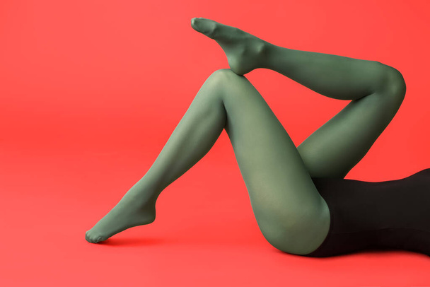 Beautiful young woman in tights on color background - Valokuva, kuva