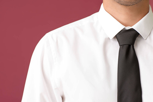 Fiatal üzletember elegáns ing színes háttér, közelkép - Fotó, kép