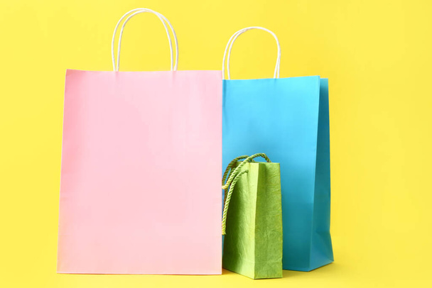 Paper shopping bags on color background - 写真・画像