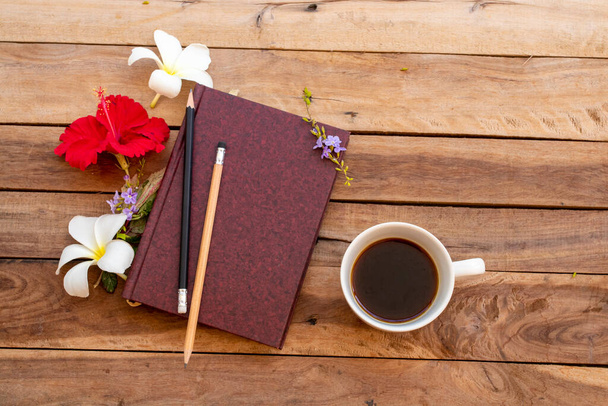 Планувальник ноутбуків для бізнесу для роботи з гарячою кавою, облаштування гібіскусу червоних квітів плоский стиль на фоні дерев'яного
 - Фото, зображення