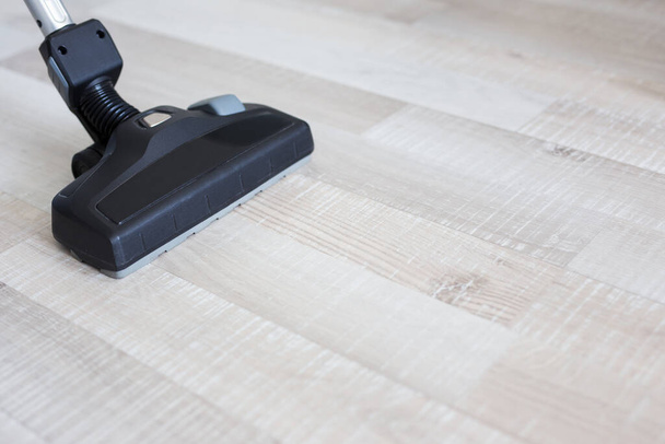 close up of modern vacuum cleaner over wooden parquet floor background - Photo, image