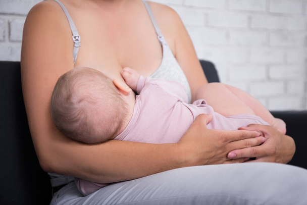 mother breastfeeding her newborn baby girl at home - Photo, Image
