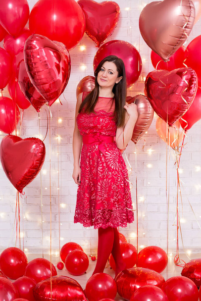 Ganzkörperporträt der schönen jungen Frau in rotem Kleid mit herzförmigen Luftballons - Foto, Bild