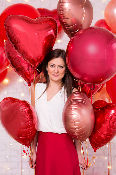 love and valentine's day concept - portrait of pretty woman with red heart-shaped balloons - 写真・画像