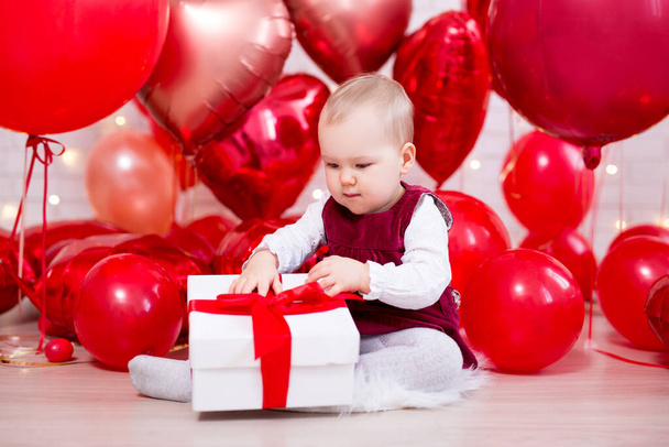 Sevgililer Günü konsepti. Hediye kutusu ve kırmızı balonları olan küçük tatlı bir kız bebek. - Fotoğraf, Görsel