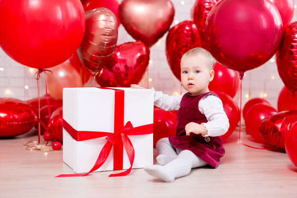 Sevgililer Günü konsepti. Kırmızı balonları ve büyük hediye kutusuyla komik küçük bir kızın portresi. - Fotoğraf, Görsel