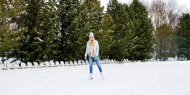 onnellinen nuori nainen ulkona luistelu jäähalli - Valokuva, kuva