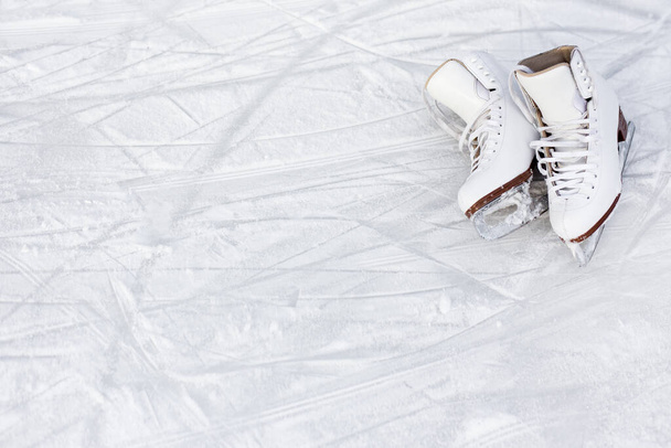 Nahaufnahme von weißen Eiskunstläufern und Kopie von Raum über Eisgrund mit Markierungen vom Eislaufen - Foto, Bild