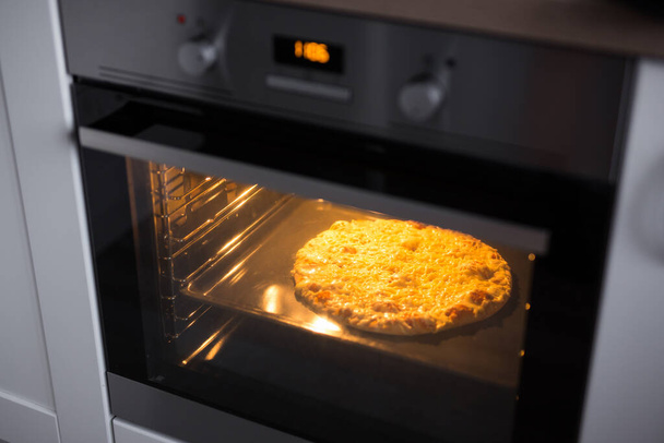 homemade cheese pizza in modern oven - Photo, Image